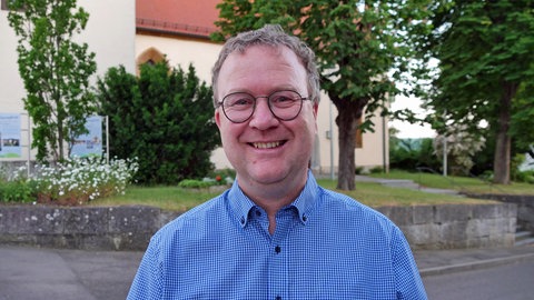Der evangelische Dekan des Ulmer Münsters, Torsten Krannich, strahlt in die Kamera. 