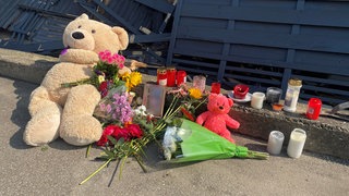 Blumen, Kerzen und Teddys auf dem Gehweg an der B28 in Blaustein (Alb-Donau.Kreis) erinnern an den tragischen Unfall am Donnerstag.   Ein Kind war an der Stelle des Gehwegs von einem Auto erfasst und getötet worden. 