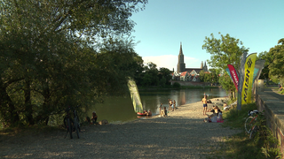 Die Donau in Ulm an einem Sommerabend, im Hintergrund ist das Ulmer Münster zu sehen.