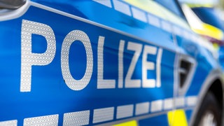Schriftzug Polizei auf einem Einsatzfahrzeug. "Zustände wie im Wilden Westen": So beschreibt die Polizei Handgreiflichkeiten zwischen einem Lkw-Fahrer und Wohnmobilisten nach einem Unfall auf der B30 bei Ulm.