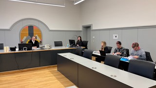 Am Amtsgericht Ulm ist am Montag ein Urteil gegen zwei Klimaaktivisten (zweite und dritte von rechts, neben ihrem Laienverteidiger) wegen einer nicht genehmigten Abseilaktion im Jahr 2023 nahe der Adenauerbrücke in Ulm gefallen.