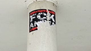 Ein Aufkleber mit rechtsextremem Inhalt klebt an einer Wand der Schillerschule in Erbach.