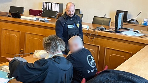 Wegen Waffenhandels muss sich ein Paar aus Neresheim im Ostalbkreis vor dem Ellwanger Landgericht verantworten. Auch im Gerichtssaal lässt der Angeklagte keinen Zweifel an seiner Gesinnung. Auf seinem T-Shirt steht das Wort "racist".