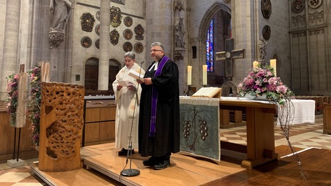 Zwei Geistliche in einer Kirche: Im Anatomie-Gottesdienst im Ulmer Münster nehmen Angehörige, Freunde und Studierende Abschied von Menschen, die ihren Körper der Wissenschaft gespendet haben.