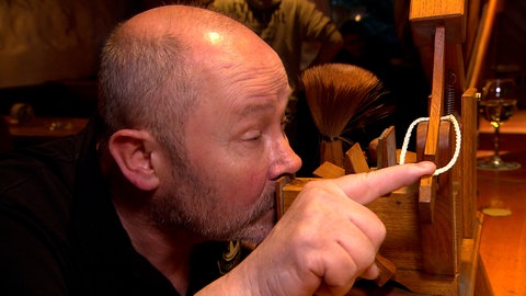 Ein Mann an einer kuriosen Schnupftabak-Maschine