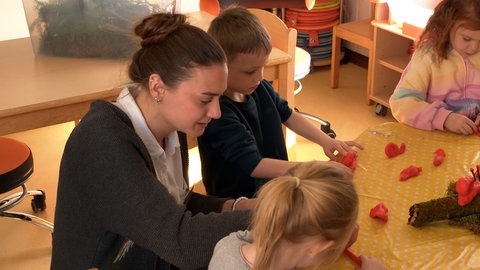 Svenja Posiadlo beim Schneckenbasteln im Kinderhaus Schillerstraße in Munderkingen (Alb-Donau-Kreis): Sie ist eine von rund 1.700 Quereinsteigern in Kitas, ausgebildet durch ein Programm des Landes Baden-Württemberg, um Personalmangel entgegenzuwirken.