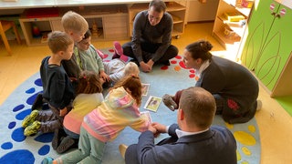 Arbeiten in Augenhöhe mit den Kindern: Azubi Svenja Posiadlo erzählt im Kinderhaus Schillerstraße die Geschichte von der einsamen Schnecke. Sie ist eine von rund 1.700 Quereinsteigern in Kitas, ausgebildet durch ein Programm des Landes Baden-Württemberg, um Personalmangel entgegenzuwirken.