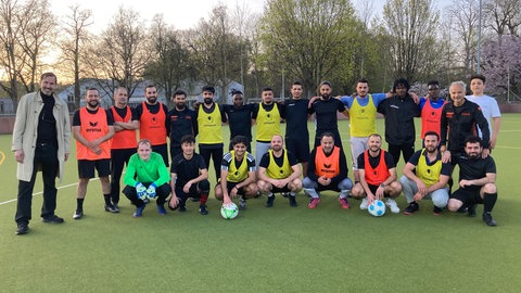 Deutsch lernen mit Kick: Immer wieder stoßen Spieler aus neuen Ländern dazu. Im Moment stammen die Spieler unter anderem aus Afghanistan, dem Irak, aus Palästina, Bosnien, Serbien, Pakistan und Kamerun. Ganz rechts, in Schwarz: Trainer Kürsat Celik - links mit heller Jacke: Christoph Hantel, Leiter der Ulmer Volkshochschule. 