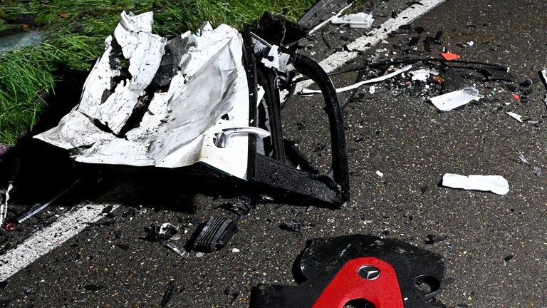 Teile der verunglückten Fahrzeuge liegen nach dem Unfall in Ulm auf der Straße. Die beiden Pkw waren auf der nassen Fahrbahn frontal zusammengestoßen. 