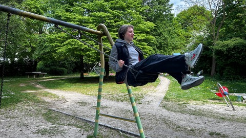 Marta sitzt auf einer Schaukel. Wenn sie schaukelt, kann Marta für einen Moment all das vergessen, was passiert ist. 