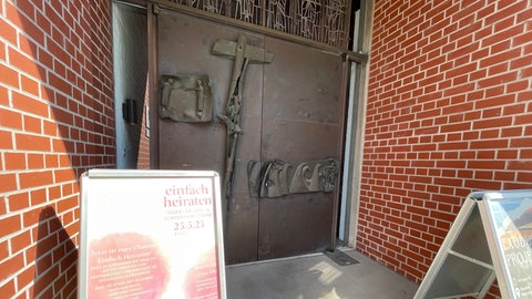 Ein Schild am Eingang der Petruskirche in Neu-Ulm weist schon daraufhin: Am 25. Mai können Paare dort spontan und einfach heiraten oder sich segnen lassen. 