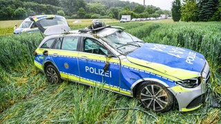 Ein völlig ramponiertes Polizeiauto in einem Feld an der B29. Der Wagen war auf der Anfahrt zu einer Unfallstelle ins Schleudern gekommen und hatte sich überschlagen.