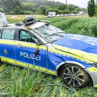 Ein völlig ramponiertes Polizeiauto in einem Feld an der B29. Der Wagen war auf der Anfahrt zu einer Unfallstelle ins Schleudern gekommen und hatte sich überschlagen.