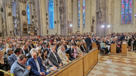 Menschen in Kirchenbänken: Etwa 1.800 Menschen sind ins Ulmer Münster gekommen, um der Schwörrede zu lauschen.