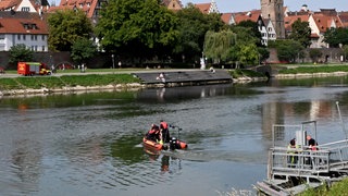 Ein Motorboot der DLRG auf der Donau am Neu-Ulmer Ufer, darauf vier Rettungskräfte. Sie suchten am Donnerstag auf der Donau nach dem Ertrunkenen.