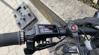 Ein Fahrradlenker auf dem an einer Bedieneinheit "ebike gesperrt" angezeigt wird. Je nach Modell ist in E-Bikes eine elektronische Sperre eingebaut. Sie soll das Rad vor Diebstahl schützen. Nur mit dem richtigen Schlüssel - auf Bedienelement oder Handy - kann es entsperrt werden. Auch ein GPS-Tracker ist gleich mit dabei. Die sollen es Dieben schwer machen. 