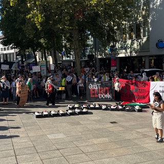 Demonstrierende mit Plakaten am Ulmer Münsterplatz. Mehrere hundert Menschen haben in Ulm gegen den israelischen Rüstungskonzern Elbit und für ein freies Palästina demonstriert.