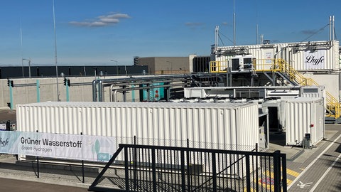 Die Container und Rohre wirken auf den ersten Blick recht unspektakulär, aber hier in der Wasserstoffproduktionsanlage in Schwäbisch Gmünd sollen täglich vier Tonnen grüner Wasserstoff erzeugt werden. 