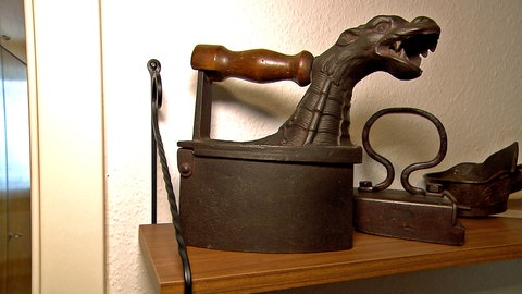 Ein Kamineisen mit einem Drachenkopf für den Rauch. Dieses Bügeleisen wurde mit glühenden Holzkohlen befüllt. Eines der Schmuckstücke der Ulmer Sammlung.