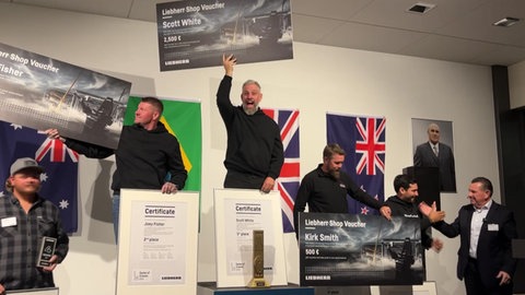 Siegerehrung der Kranweltmeister: Auf dem Treppchen ganz oben freut sich der frisch gekürte Kranweltmeister Scott White. Der Engländer holte den Titel im "Game of Cranes" nach Europa und setzte sich gegen vier Kontrahenten im Finale durch. Platz zwei ging nach Australien, Platz drei nach Neuseeland.
