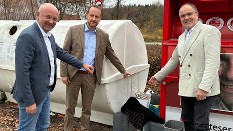 Drei Männer stehen vor einem Container und zeigen auf Müll. Der wird dort immer wieder illegal abgeladen. Deswegen fordern die Städte Aalen, Ellwangen und Schwäbisch Gmünd mehr Freiheiten bei der Einrichtung von Videoüberwachung.