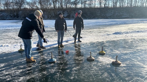Junge Menschen haben Spaß beim Eisstockschießen auf dem Buschelbergsee bei Nersingen (Kreis Neu-Ulm). Für sie ist es das erste Mal seit vielen Jahren, dass man auf den See kann. 