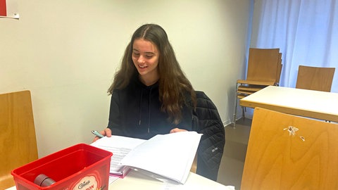 Natalie bei der ehrenamtlichen Arbeit - hier wirft sie nochmal einen Blick in die Unterlagen, bevor ihre Hausaufgabenhilfe in der Flüchtlingsunterkunft beginnt.