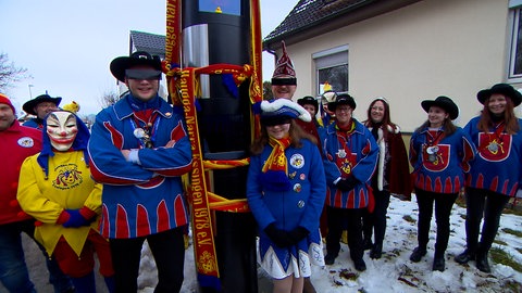 Die Haugga-Narra posieren vor dem Blitzer in Essingen. Die Haugga-Narra und ihr Blitzer: Als präventive Maßnahme für kommende Fotos verkaufen die Narren aus Essingen mittlerweile Balkenbrillen als "Zensierhilfe". 
