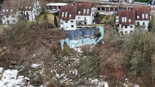 Abgerutschtes Gelände vor einer Häuserzeile. Bei dem Hangrutsch in Bettringen handelt es sich laut geotechnischem Gutachten der Stadt um ein komplexes Rutschungssystem mit einer Länge von rund 160 Metern und einer Breite von rund 60 Metern. 