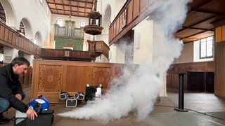 Thomas Löther betätigt die Nebelmaschiene in der Langenauer Martinskirche.