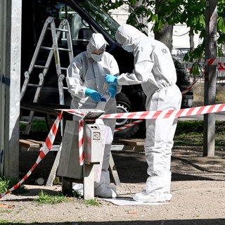Beamte der Spurensicherung in weißen Ganzkörpernanzügen. Der Bereich um den Tatort am Karlsplatz in Ulm ist für die Spurensicherung weiträumig abgesperrt worden. Die Auswertung liegt nun beim Landeskriminalamt.