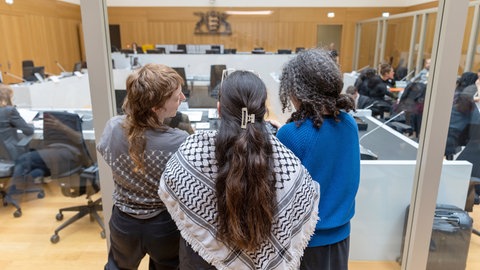 Prozessbeobachterinnen stehen im Gerichtssaal in Stuttgart-Stammheim, wo fünf Pro-Palästina-Aktivisten vor Gericht stehen. 