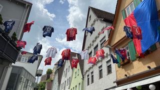 Vor dem Café Mélange hat Wirt Frank Zeger seine Trikotsammlung für den letzten Spieltag aufgehängt. 