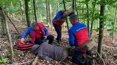 Ein Suchtrupp der Bergwachten Heidenheim und Herbrechtingen haben die Verletzte im Wald gefunden und versorgen sie.  