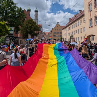 Beim CSD in Ulm soll am Samstag die längste Regenbogenfahne Deutschlands durch die Stadt getragen werden. Auf dem Foto sieht man ein Teilstück der Fahne bei der Pride-Parade in Augsburg. (Symbolbild)