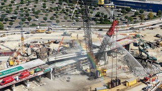 Das letzte Stück der Brücke über dem Blaubeurer Tor wird herausgehoben. Das historische Bauwerk wurde für den Rückbau in Schutzfolie eingewickelt.