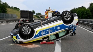 Ein Polizeiauto liegt nach einem Unfall auf dem Dach. Bei den Aufräumarbeiten nach einem Lkw-Unfall auf der A8 bei Leipheim ist am Dienstagabend ein Polizeiauto wegen eines Fahrfehlers umgestürzt und auf dem Dach liegengeblieben.