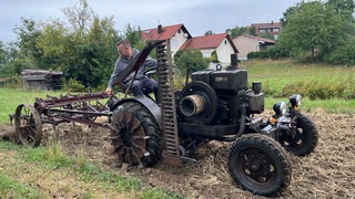 Thomas Vatter arbeitet auf dem Acker bei Ellwangen. Er benutzt dazu alte Landmaschinen. Seine Frau Pamela filmt ihn dabei für Youtube.