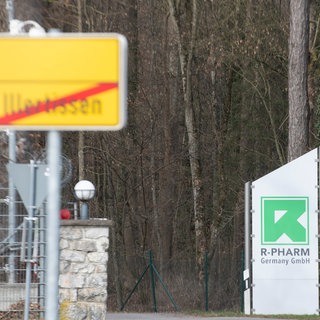 Das Ortsschild von Illertissen und ein Schild mit Logo der Firma R-Pharm. Der Pharmahersteller im Kreis Neu-Ulm schließt.