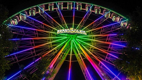 Ein Riesenrad leuchtet bunt im Dunkeln. Dieses Exemplar soll Anfang Oktober vor dem Ulmer Münster stehen.