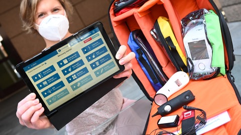 Nadine Durmazel, Hausärztin aus Alzey, stellt beim Start des rheinland-pfälzischen Pilotprojekts "Telemedizin-Assistenz" auf dem Hof des Sozialministeriums einen Tablet-Computer sowie einen Rucksack mit telemedizinischer Ausrüstung vor.