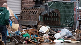 Mit einem Bagger werden Trümmer beseitigt. 