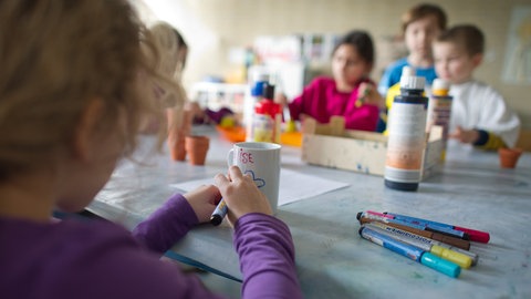 Grundschüler sind in einem Hort mit Bastelarbeiten beschäftigt. 