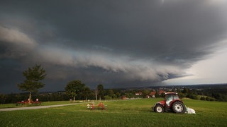 Gewitterwolken über einem Traktor
