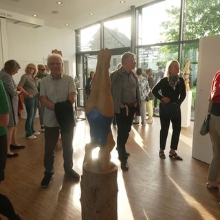 Besucher laufen durch einen Ausstellungsraum