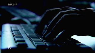 Tippende Finger an der Tastatur in mysteriöser Atmosphäre