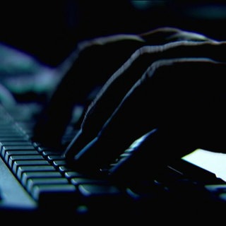 Tippende Finger an der Tastatur in mysteriöser Atmosphäre