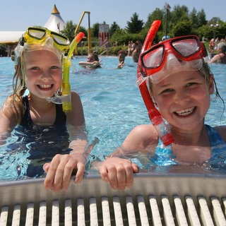 Kinder im Schwimmbad. In den Sommerferien in Rheinland-Pfalz erwartet ARD-Meteorologe Marcel Herber "typisches Sommerwetter". 