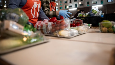 Tafel-Mitarbeiterinnen sortieren die Ware auf Tabletts für die Ausgabe. Auch in Rheinland-Pfalz berichten Tafeln, dass sie mehr Bedürftige versorgen müssten.
