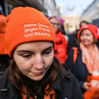 Eine Frau trägt bei einer Mahnwache eine Mütze mit der Aufschrift "Keine Gewalt gegen Frauen und Mädchen" (Archivbild).